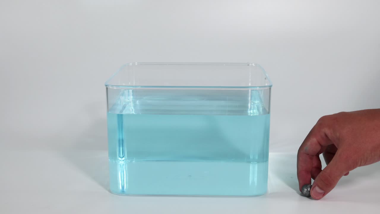 마그네트는 물로 가득 찬 용기 주위에 움직입니다.