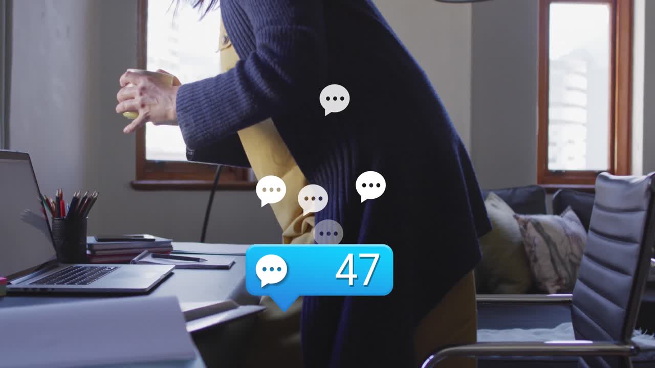 animación de iconos de mensajes flotando sobre una mujer anciana caucásica con una taza de café sentada en casa.