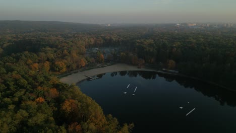 głębokie lake in szczecin surrounded by autumn trees and calm morning light, aerial view