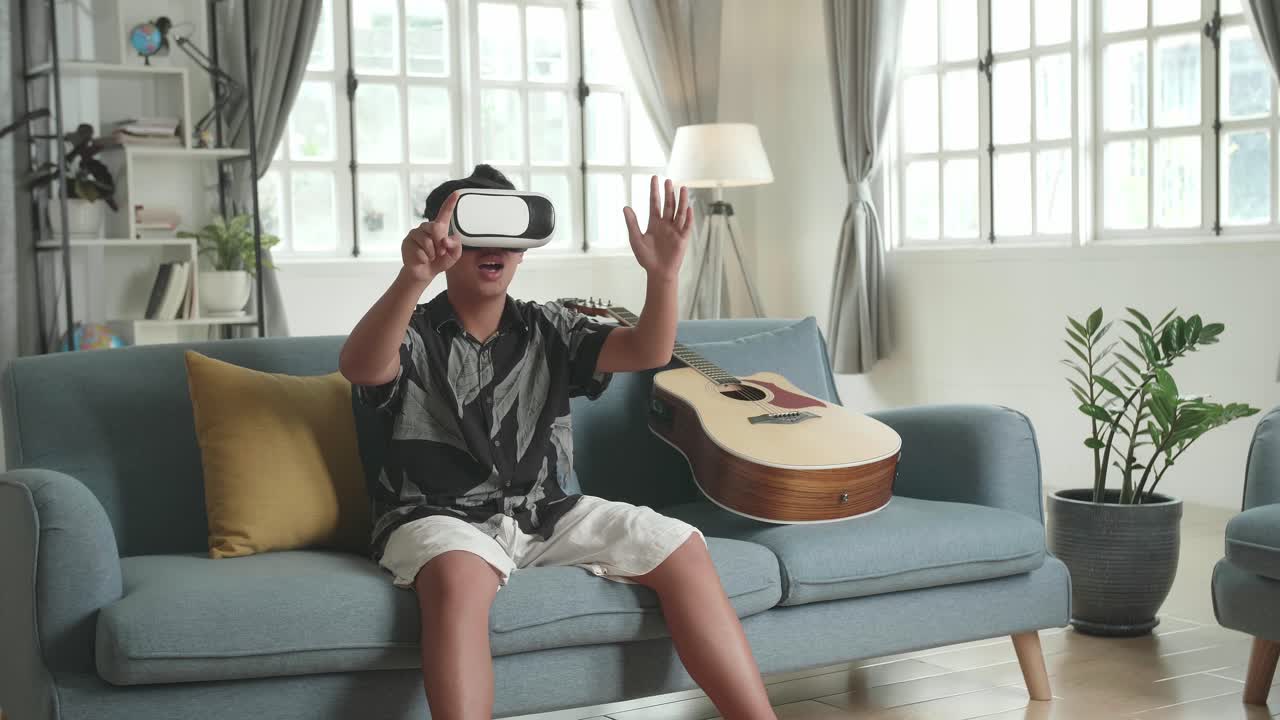 Boy Wearing VR Headset, Playing Music, on Sofa