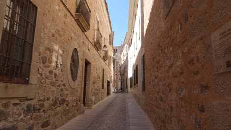 typical narrow street from caceres old town, historic stone walls