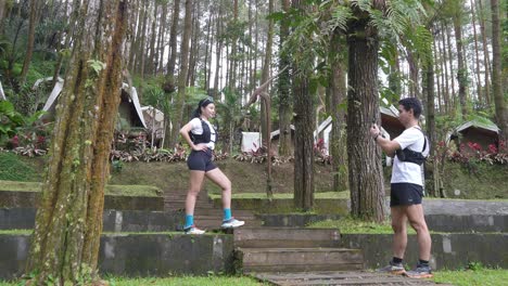 asian couple taking photos during outdoor adventure in forest