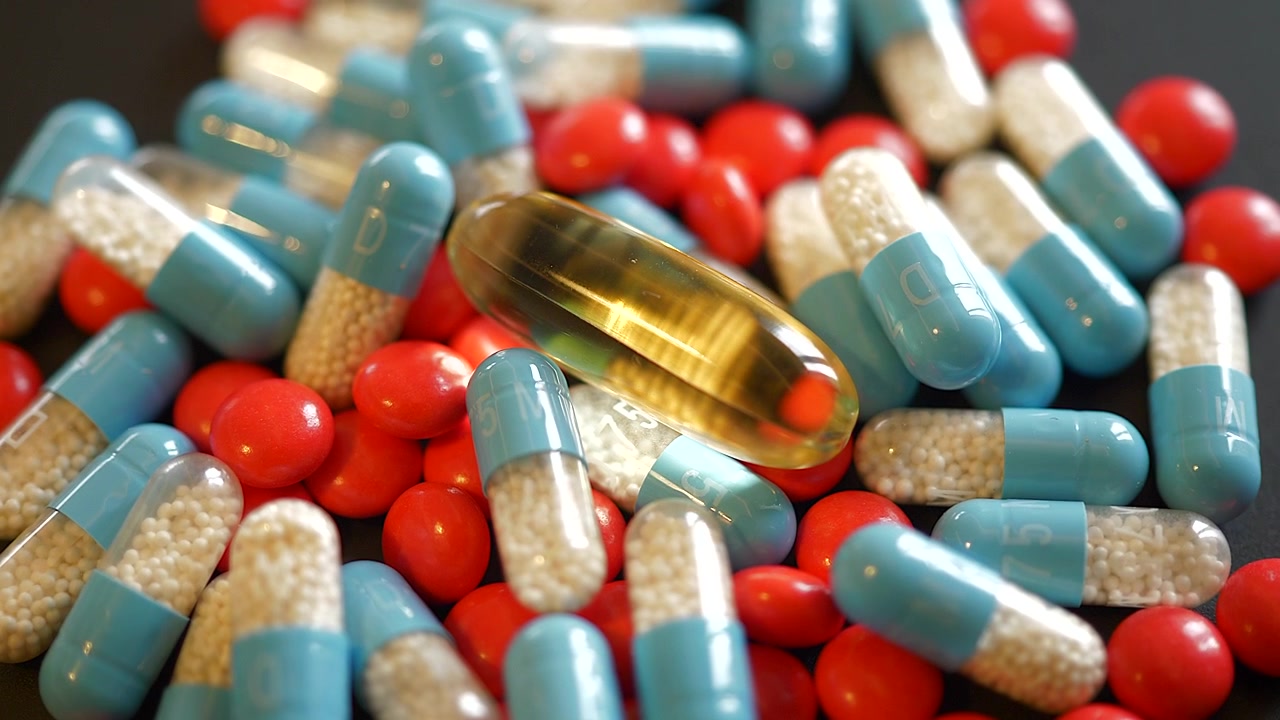 Assorted Pharmaceutical Capsules and Tablets on Dark Surface