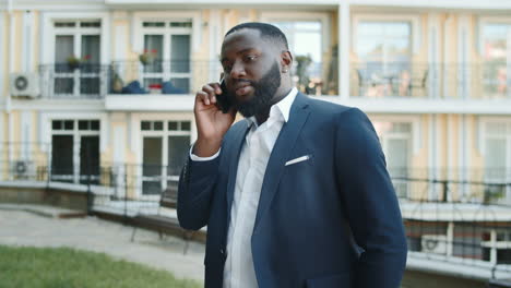 Serious-african-businessman-talking-on-phone-outside.-Man-having-conversation