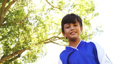 smiling boy playing a football in park