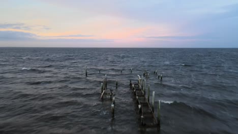 serene sunset over the ocean with a broken pier
