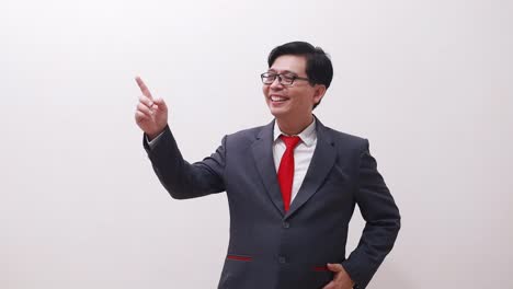 joyful asian businessman in suit standing while pointing both sides on right and left