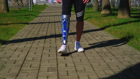 man with prosthetic leg walking in a park