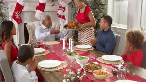 grandmother brings out turkey at christmas meal shot on r3d