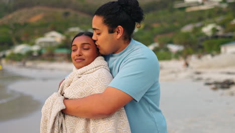 Blanket,-comfort-and-couple-hug-at-the-beach-due