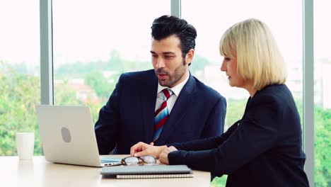 Two-business-people-talk-project-strategy-at-office