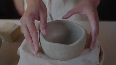 woman handcrafting a clay bowl