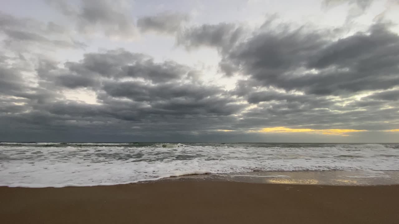 해변을 따라 파도가 천천히 모래 위로 굴러