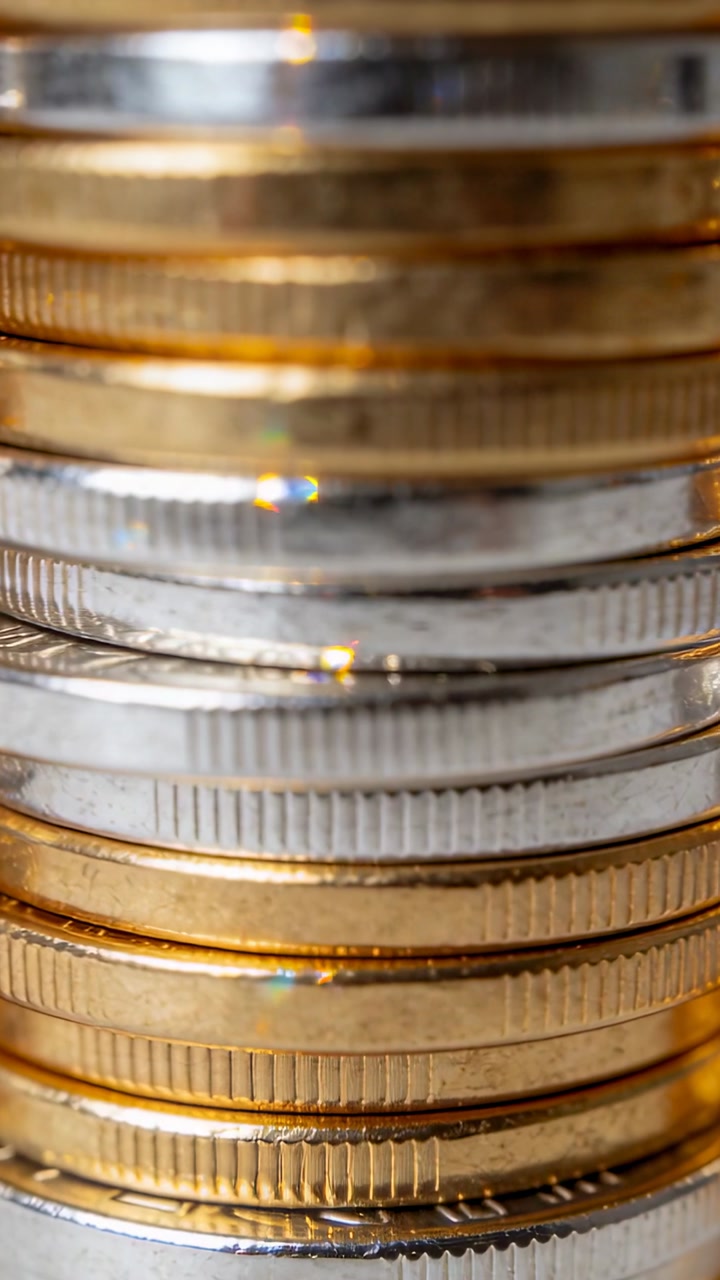 Vertical video: Shifting camera focus showing coin stack reeded edges and two-tone rims in studio