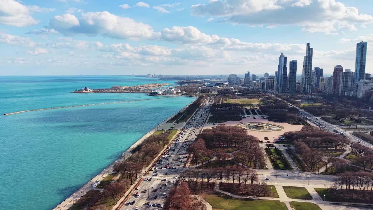 Uma ampla vista aérea do horizonte de Chicago, apresentando a exuberante vegetação do Parque, a histórica Fonte de Buckingham e a vasta extensão do Lago Michigan.