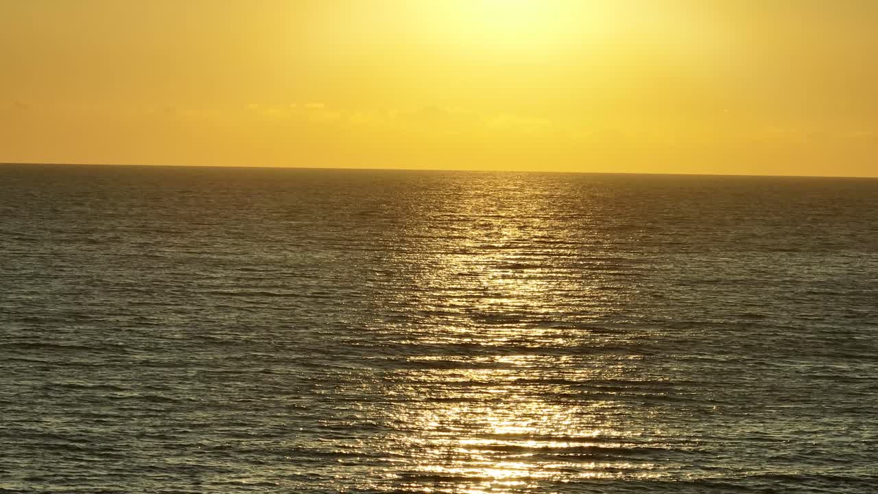 해가 지는 동안 작은 파도와 함께 아름다운 평온한 바다