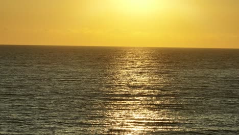 hermoso mar tranquilo con pequeñas olas durante la puesta de sol