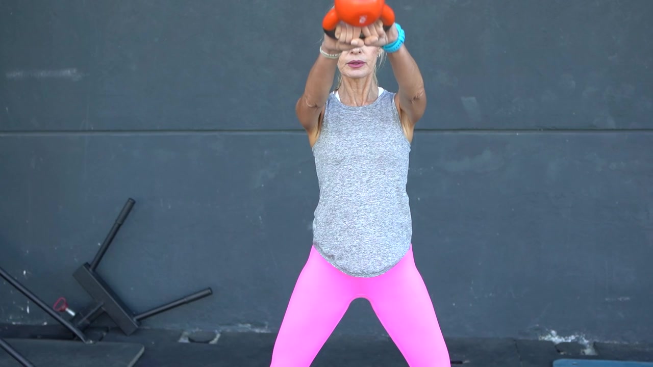 Atleta in forma che esegue un esercizio di kettlebell swing in palestra