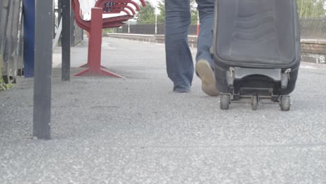 commuter wheels suitcase on train platform wide shot