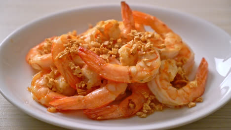 fried shrimps or prawns with garlic on white plate - seafood style