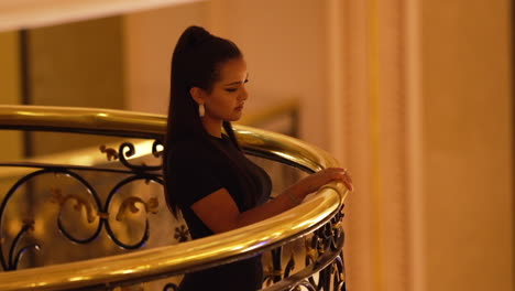 Portrait-of-a-beautiful-elegant-young-woman-wearing-a-black-dress,-looking-at-the-camera-and-smiling-softly