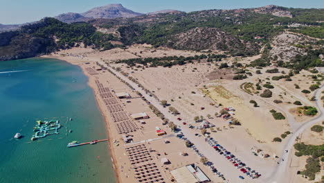 vista aérea de una playa de arena con sombrillas y camas de sol en un día soleado