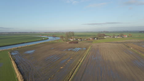 aerial of muddy meadows near a small farm