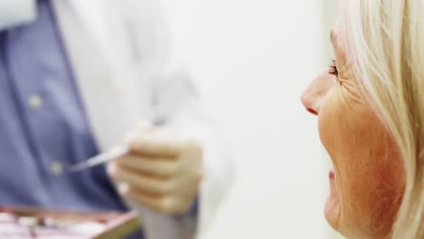 Dentist-interacting-with-female-patient