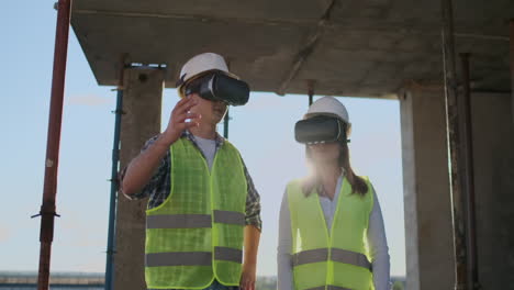 un hombre y una mujer ingenieros en un sitio de construcción en vr gafas manejan la construcción de un edificio discutiendo un plan de desarrollo