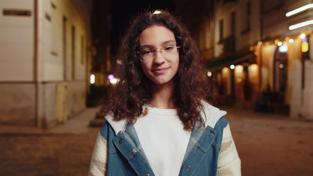 Ritratto di una giovane donna felice e carina con un'espressione di gioia sorridente che guarda la telecamera in una strada della città