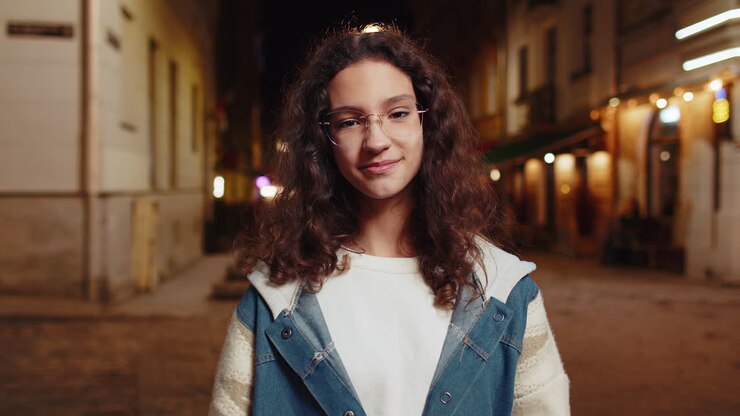 Ritratto di una giovane donna felice e carina con un'espressione di gioia sorridente che guarda la telecamera in una strada della città