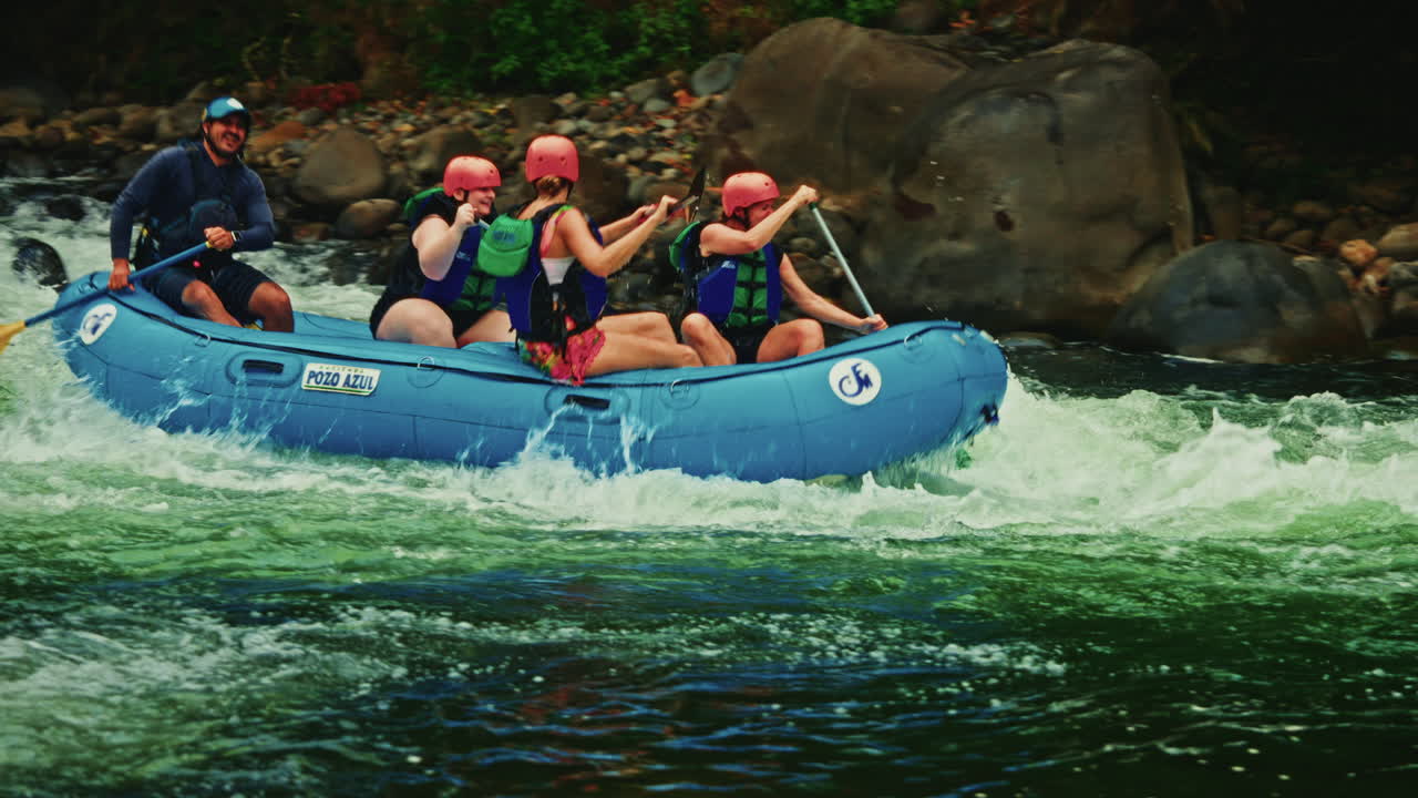 Slow motion. Group of friends enjoying river rafting in Costa Rica ...