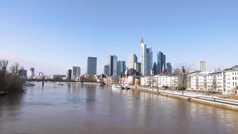 Frankfurt-Skyline-And-Eiserner-Steg-Over-Main-River-With-Passenger-Ship-At-Daytime-From-Alte-Brucke-Bridge-In-Frankfurt-am-Main,-Germany