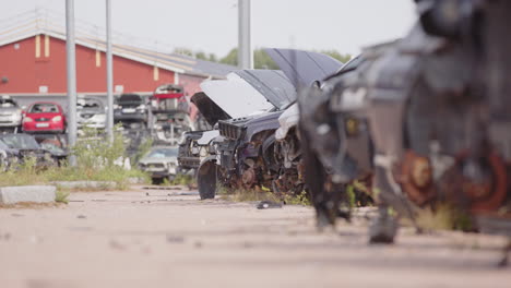 Rusty-wrecks-of-retired-vehicles-dumped-at-scrapyard,-low-slider