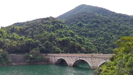 Schöner-Tai-Tam-Reservoir-In-Hong-Kong,-Historischer-Dammbrückenarchitekturblick-Und-Berglandschaft,-Schwenkaufnahme