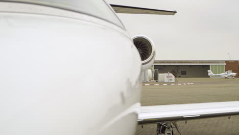 pan shot showing luxury white cessna airplane parking on private airport