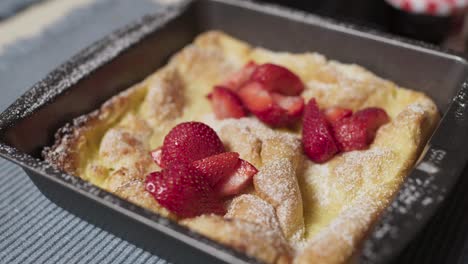 a panakuken with strawberries and powdered sugar