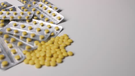 Yellow-pills-with-packages-on-white-background