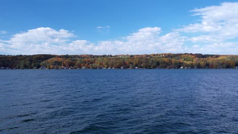 Water-level-aerial-view-from-drone-skimming-across-Keuka-Lake-in-the-Finger-Lakes,-NY