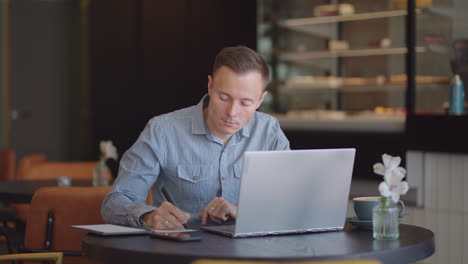 young freelancer man working on computer at home. casual concentrated entrepreneur developing new project while working on laptop at home. male professional typing laptop keyboard at office workplace