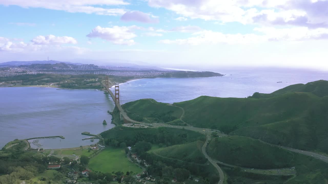 Drone shot of Golden Gate bridge from the Marin (North) side.  Wide shot of bridge, bay and the ocean looking South West.  Late afternoon with blue sky and mixed clouds.