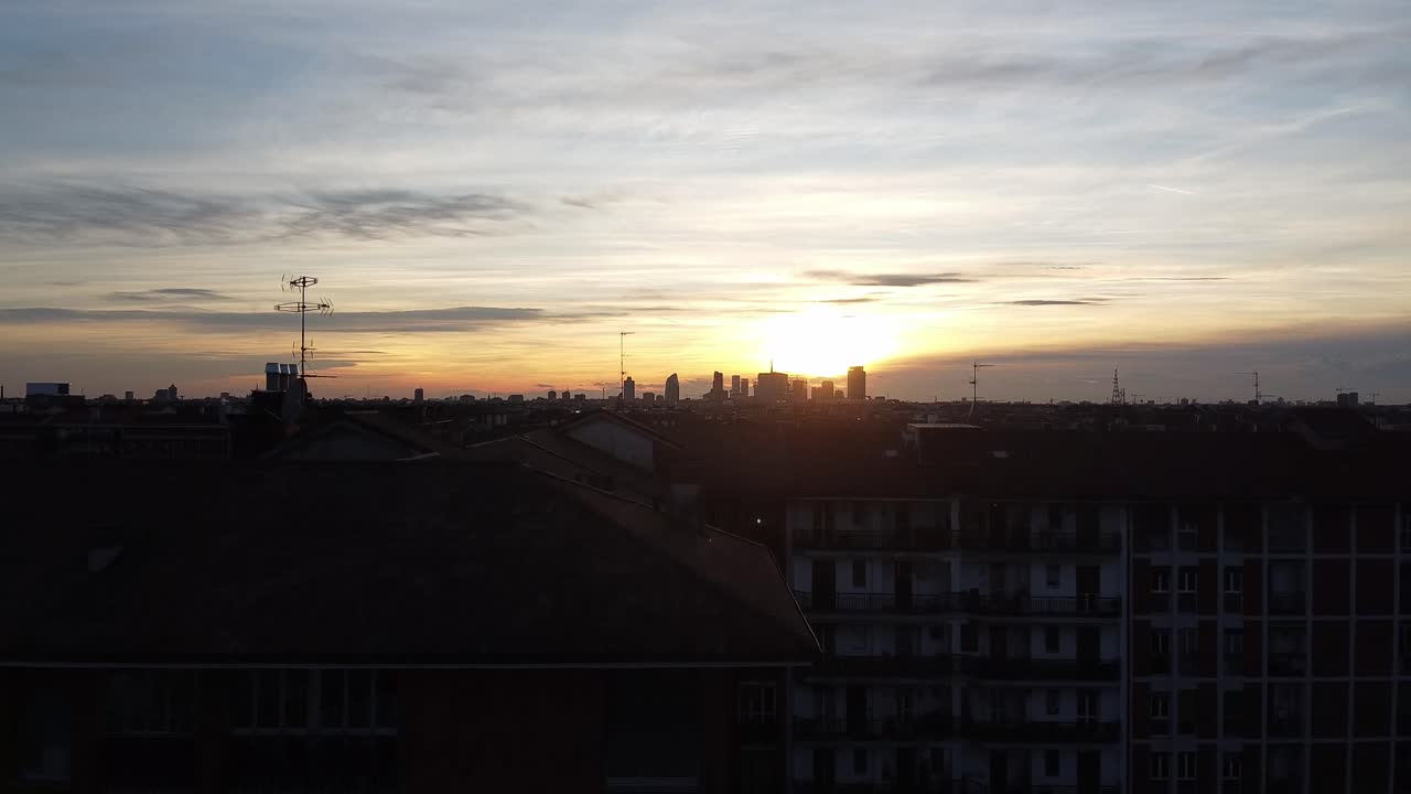 Revelando o horizonte da cidade de Milão durante o pôr do sol dourado, ascensão acima dos edifícios