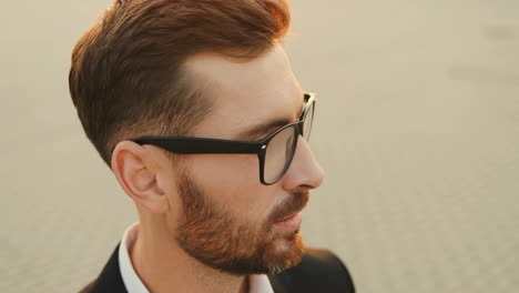 close up from above on the attractive man in glasses raising his eyes up and looking at the camera