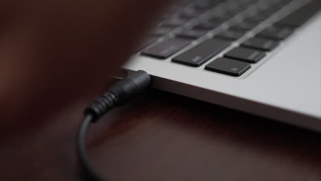 Close-up-of-plugging-in-a-headphone-jack-and-usb-cord-in