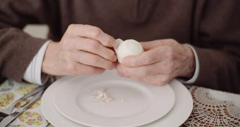 anciano pelando huevo en plato 2