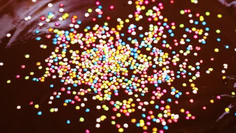 colorful sprinkles scatter over smooth chocolate