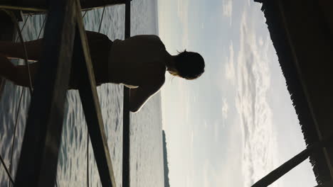 vertical slow-motion shot of a female standing on a villa balcony in bohol