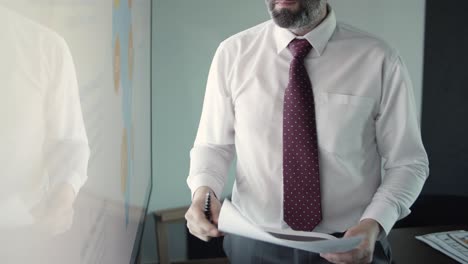 cropped businessman holding pen, talking and pointing on map