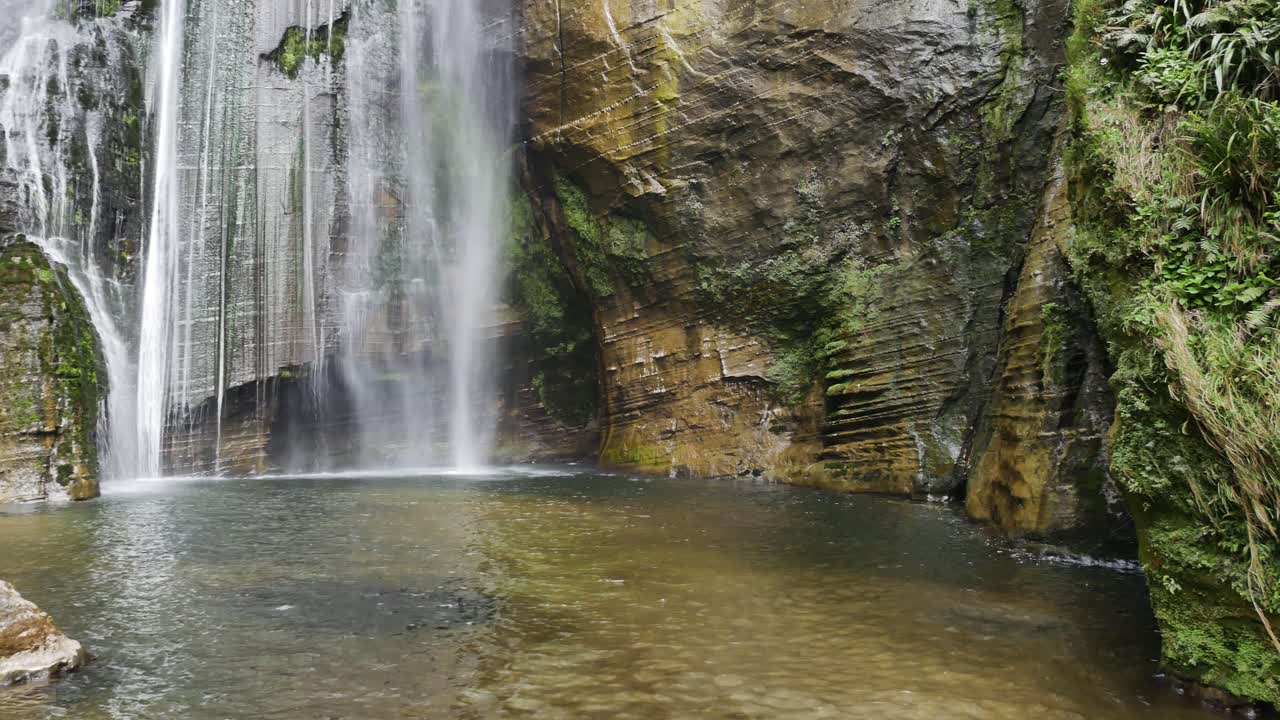 hermosa cascada que cae en una piscina de agua en la bahía de hawkes de nueva zelanda
