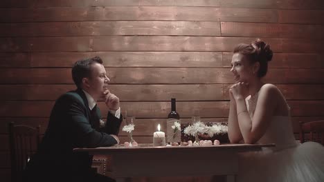 Newlyweds-in-a-wedding-dress-sitting-in-a-restaurant-and-talking-during-dinner